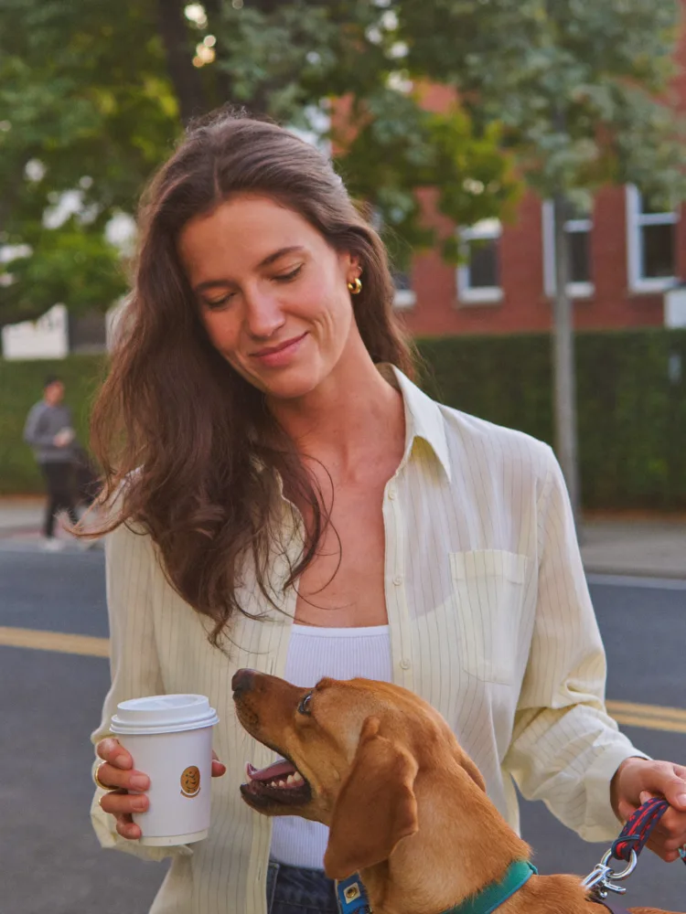 Woman on a calm morning walk with her rescue dog and coffee